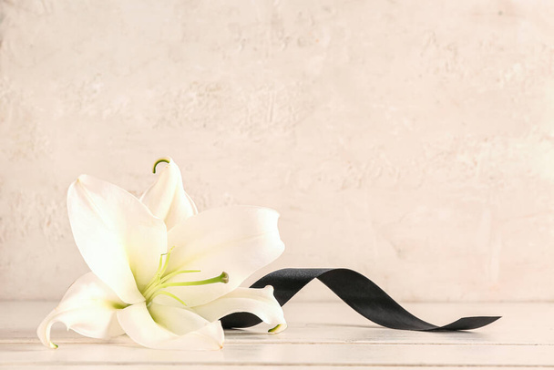 Красивая лилия с черной лентой на бежевом фоне - Фото, изображение