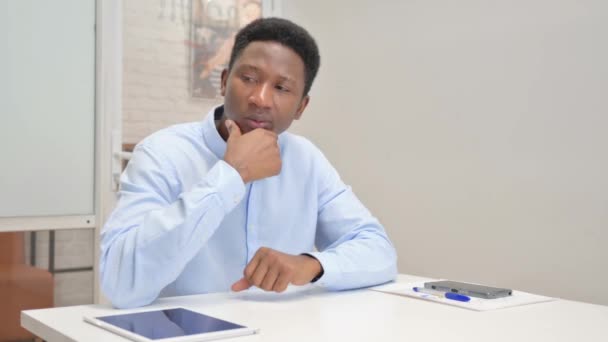Homme d'affaires africain pensif assis au bureau - Séquence, vidéo