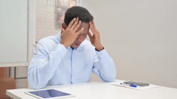 Afrikaanse zakenman die hoofdpijn heeft terwijl hij op kantoor zit - Video
