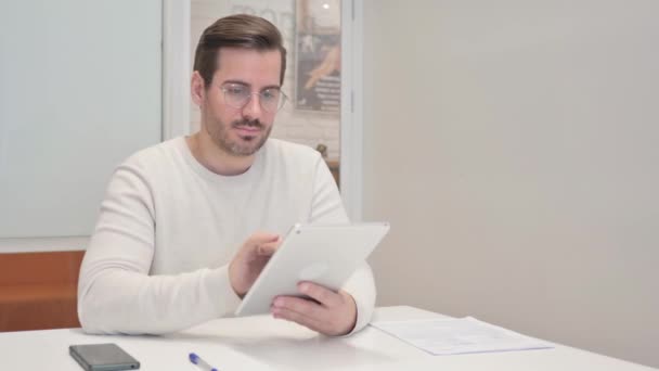Hombre de mediana edad usando tableta digital en la oficina - Metraje, vídeo