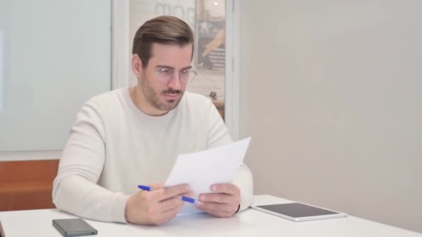Hombre de mediana edad trabajando en documentos en la oficina - Metraje, vídeo