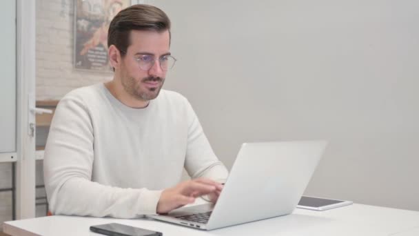 Hombre de mediana edad que trabaja en el ordenador portátil en la oficina - Metraje, vídeo