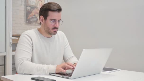 Hustender Mann mittleren Alters benutzt Laptop im Büro - Filmmaterial, Video