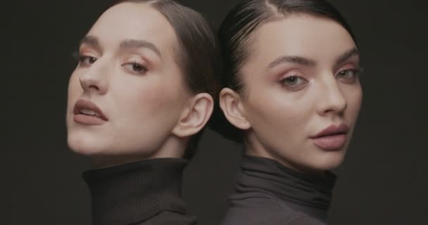 Duas jovens mulheres elegantes com boa maquiagem em um fundo preto. Movimento lento, Estúdio tiro. - Filmagem, Vídeo