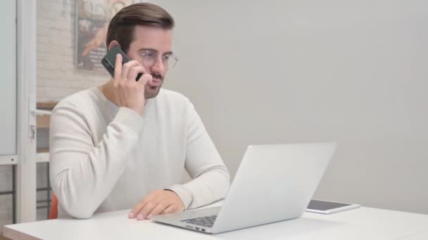 Hombre de mediana edad hablando por teléfono en el trabajo - Imágenes, Vídeo