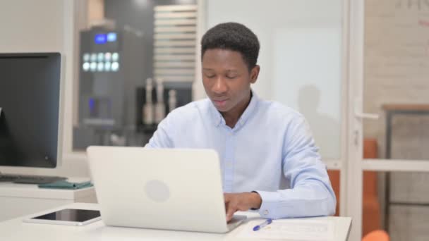 Pensativo empresario africano que trabaja en el ordenador portátil - Imágenes, Vídeo