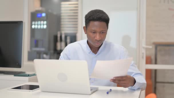 Empresario africano leyendo documentos en el trabajo - Imágenes, Vídeo