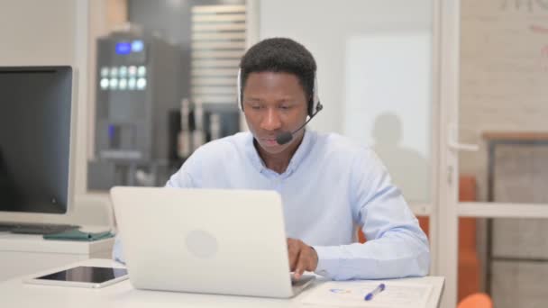 Homme africain avec casque regardant la caméra dans le centre d'appels - Séquence, vidéo