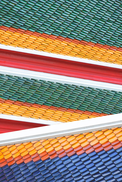Минимальный стиль фона разноцветной традиционной имбриационной керамической плитки крыши тайского храма в вертикальной рамке - Фото, изображение