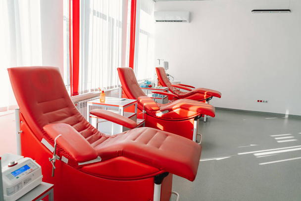 Czerwone fotele do siedzenia w centrum darowizn. Stacja transfuzji krwi do pobierania krwi od dawców - Zdjęcie, obraz