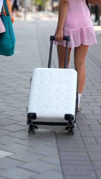 Deux jolies jeunes femmes en balade en ville avec une valise. Images 4k de haute qualité - Séquence, vidéo