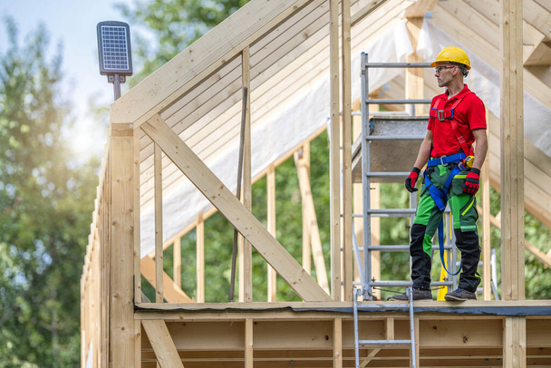 Ammattimainen rakennustyöläinen hänen 40s yllään kova hattu Asuminen talon luuranko Frame - Valokuva, kuva