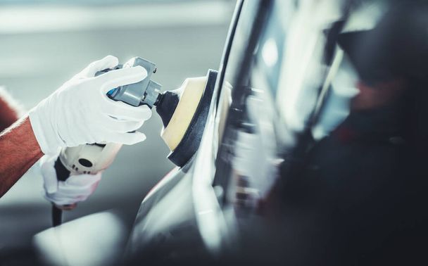 Professional Detailer Automotive Worker Polishing Vehicle Body After Waxing Close Up Photo - Photo, Image