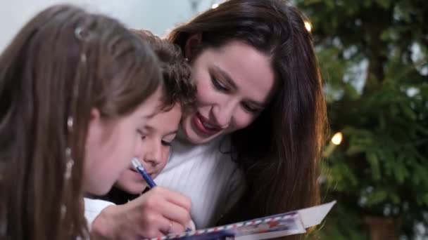Anya és a gyerekek levelet írnak a Mikulásnak. Újévi és karácsonyi ajándékok. - Felvétel, videó