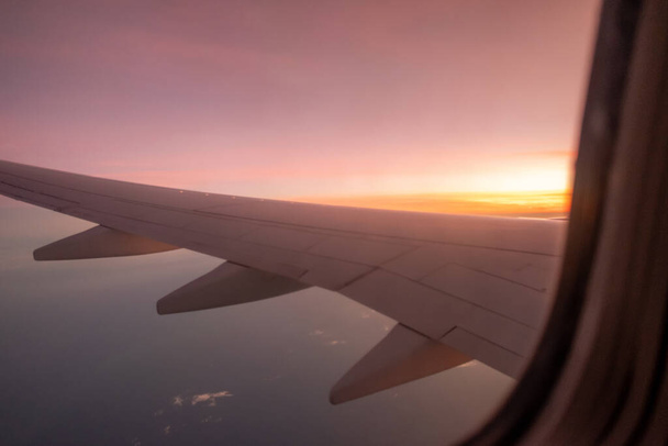 Ουρανός, σύννεφο κατά την ανατολή του ηλίου από το παράθυρο του αεροπλάνου. - Φωτογραφία, εικόνα
