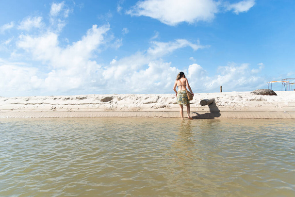 Güzel beyaz bir kadın nehri geçip karşı kıyıya geçiyor. Valenca, Brezilya 'daki Taquari Plajı. Tatilde olan kişi. - Fotoğraf, Görsel