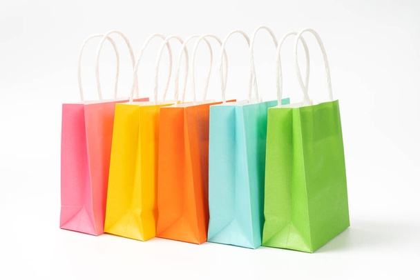 wielobarwny prezent lub torby na zakupy w rzędzie izolowane na białym tle, na sprzedaż i wydarzenie promocyjne. - Zdjęcie, obraz