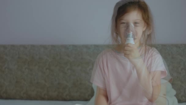 Mała dziewczynka robi inhalację z nebulizatorem w domu. Nebulizator wziewny z parą na kaszel. Stan słabości - Materiał filmowy, wideo