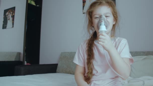Pieni tyttö tekee inhalaatiota sumuttimella kotona. Inhalaatiosumutin, jossa on lääkehöyryä yskää varten. Heikkoudet - Materiaali, video