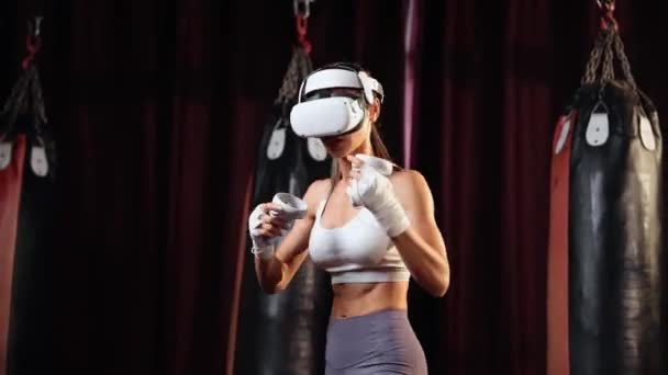 Женские тренировки боксеров с виртуальной реальностью или виртуальной реальностью, ношение VR гарнитуры с иммерсивной техникой бокса с использованием контроллера для повышения ее мастерства в боксе симулятор. Импет - Кадры, видео