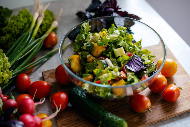 Zdrowa sałatka warzywna ze świeżych pomidorów, ogórków, cebuli, szpinaku, sałaty na talerzu. Dietetyczne menu - Zdjęcie, obraz