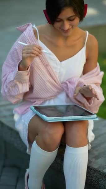 Uma jovem adorável usando um tablet enquanto trabalhava em um dia ensolarado de verão. Imagens 4k de alta qualidade - Filmagem, Vídeo