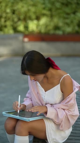 Parkta tabletle meşgul olan zarif, genç bir kadın. Yüksek kalite 4k görüntü - Video, Çekim