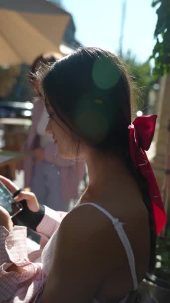 Een aantrekkelijke, jonge dame die een telefoon vasthoudt in een stedelijke omgeving. Hoge kwaliteit 4k beeldmateriaal - Video