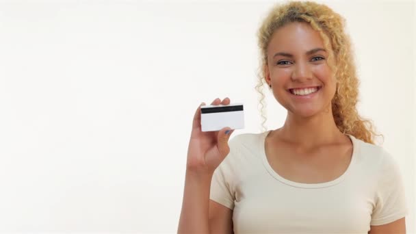 Gelukkige meisjes die duimen laten zien met een creditcard. Close-up portret van jonge lachende vrouw met credit card en duim omhoog teken, geïsoleerd op witte achtergrond. - Video