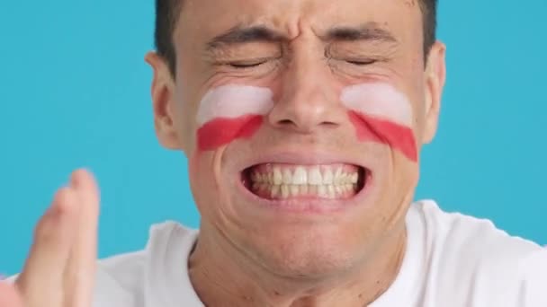 Zamknij wideo w studiu z chromą bardzo nerwowego człowieka z polską flagą pomalowaną na twarzy, wspierającego polską drużynę podczas trudnego meczu, który w końcu przegrywa - Materiał filmowy, wideo