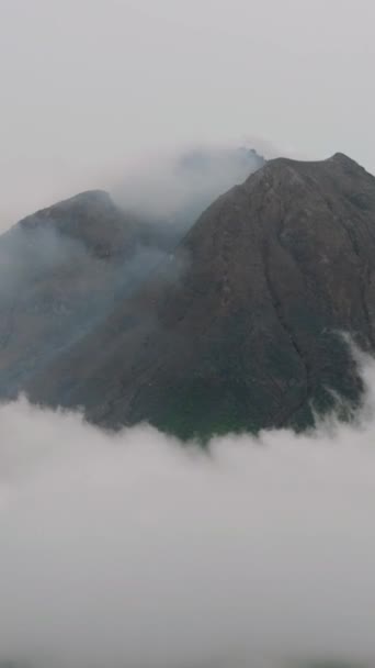 Aktiivisen tulivuoren lennokki Sinabung pilvillä ja savulla. Sumatra, Indonesia. - Materiaali, video