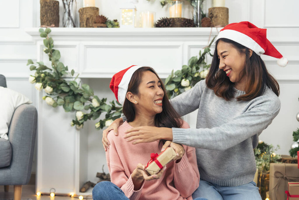 Dvě ženy sourozenci pomocí rukou zdobí vánoční stromek červený míč, cetka, sněhová vločka. Zblízka ruce drží červené koule cetka zdobí. Asijské žena přátelé decor cetka míč vánoce strom dovolená - Fotografie, Obrázek