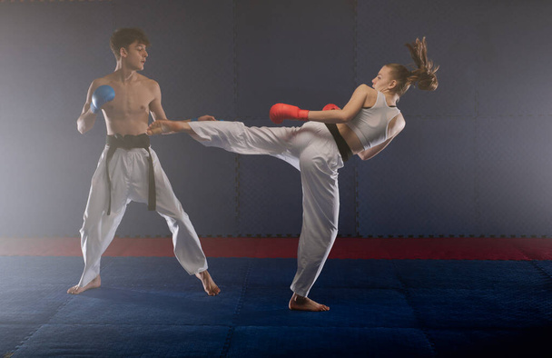 Dva mladí karatisté cvičí Ushiro Kakato v karate klubu - Fotografie, Obrázek