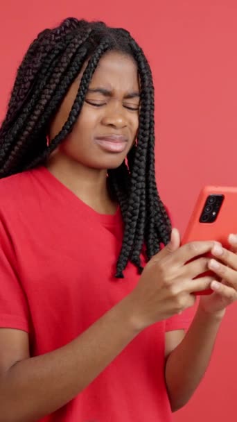 Obavy africká žena pomocí mobilního telefonu ve studiu s červeným pozadím - Záběry, video