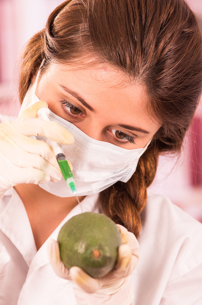 young beautiful woman biologist experimenting with avocado - Fotó, kép