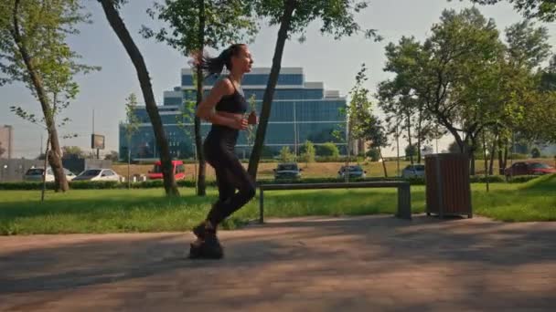 πλευρική άποψη γυναίκα τρέχει σε εξωτερικούς χώρους αστικό τοπίο καρδιο προπόνηση το καλοκαίρι πρωί αργή κίνηση - Πλάνα, βίντεο