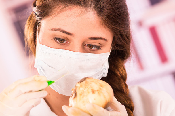 young beautiful woman biologist experimenting with white onion - Φωτογραφία, εικόνα