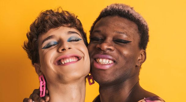 Detailní záběr dvou šťastných transsexuálních mužů usmívajících se a objímajících na žlutém pozadí - Fotografie, Obrázek