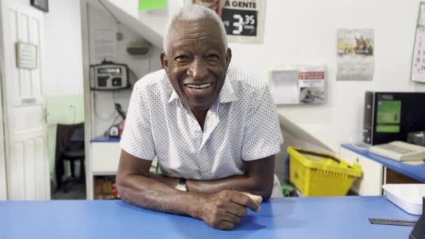 Un homme noir souriant, propriétaire du marché du quartier, derrière la perspective contraire - Séquence, vidéo