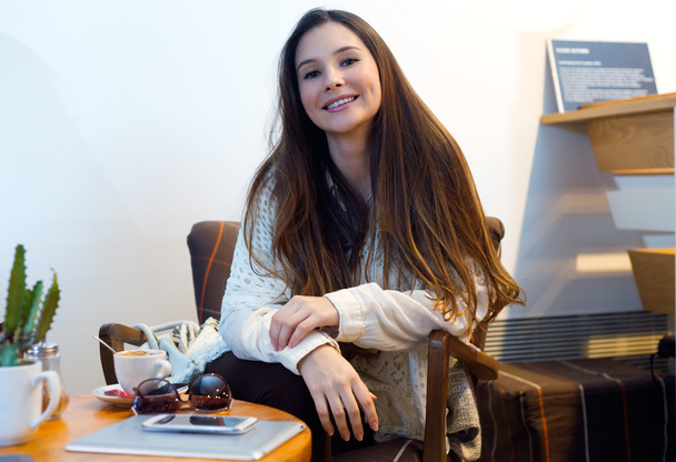 Beautiful young woman drinking coffee in cafe shop. - Zdjęcie, obraz