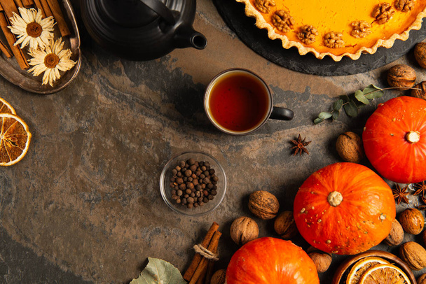 thanksgiving still life with ripe gourds, hot tea and delicious pumpkin pie on stone tabletop - Photo, Image