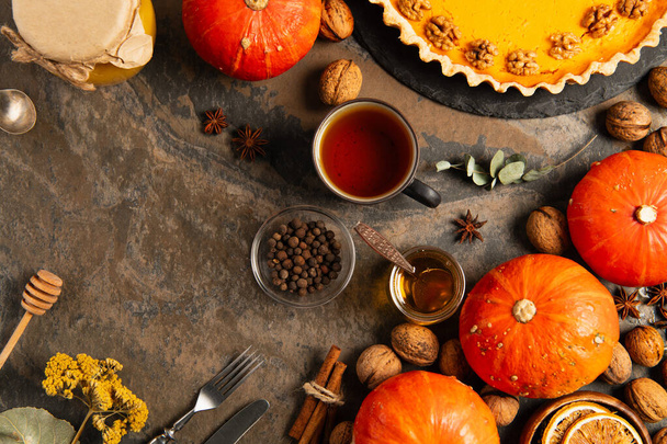 kolorowe ustawienie dziękczynienia z dojrzałych dyni i ciasto dyniowe w pobliżu herbaty, miodu i sezonowych obiektów - Zdjęcie, obraz