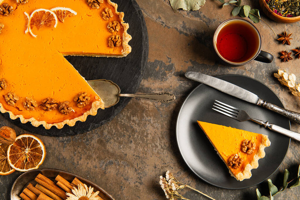 tarte à la citrouille thanksgiving près de couverts vintage et thé chaud sur table en pierre décorée, thème automnal - Photo, image
