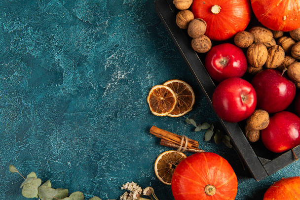 hálaadás háttér, tálca őszi betakarítás közelében narancs szeletek és gyógynövények kék texturált felületen - Fotó, kép