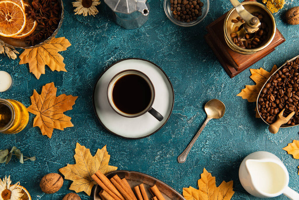 Natura morta per il Ringraziamento, tazza di caffè su un tavolo blu con foglie d'acero e decorazioni autunnali - Foto, immagini