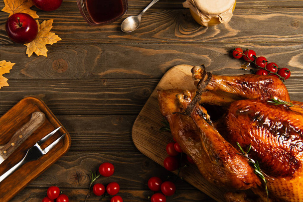 roasted turkey near honey and maple syrup on wooden table with autumnal decor, thanksgiving - Photo, Image