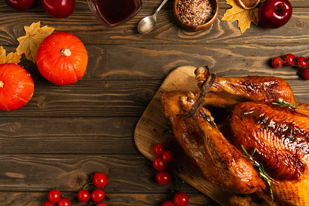 Thanksgiving toile de fond, dinde grillée près de citrouilles et épices sur table en bois avec décor automnal - Photo, image