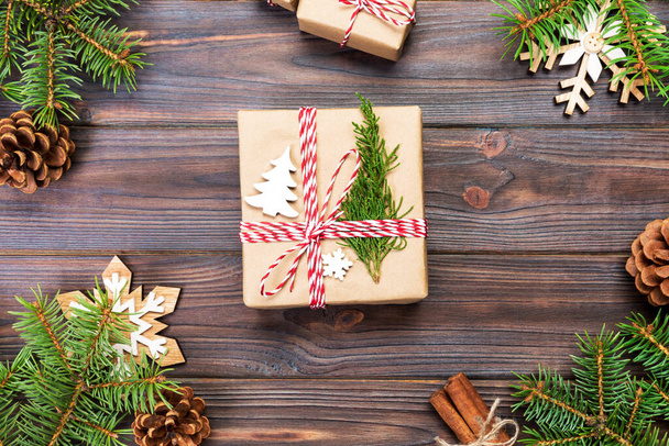 Weihnachten Hintergrund mit Tanne und Geschenkbox auf Holztisch. Draufsicht mit Kopierraum für Ihr Design. - Foto, Bild