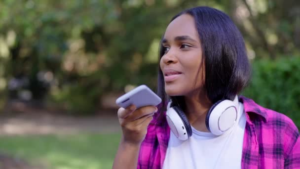 Fekete tinédzser hangpostát küld a szabadban. Afrikai amerikai fiatal nő beszél okostelefonon. - Felvétel, videó