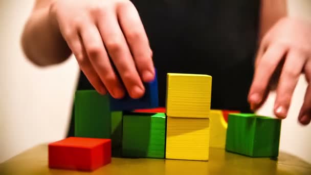 tiener jongen bouwt toren van bakstenen blokken spelen een grote hand video hd 1920 x 1080 - Video